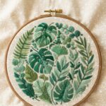 Lush green fern foliage needlework inspo on neutral linen fabric